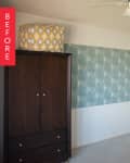 Empty room with a dark wood wardrobe, patterned cushion on top, and a large green patterned wall art.