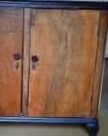 Wooden cabinet with two doors, dark top and base, and red knobs, labeled "Before" on the left side.