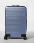 Blue hard-shell suitcase with four black wheels and a top handle.