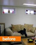Basement living room with beige sofas, decorative pillows, small windows, and a coffee table with snacks and laundry basket.