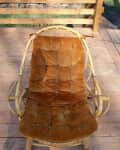 Rattan chair with a tufted brown cushion on a wooden deck, labeled "before."