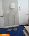 Two adjustable floor lamps with white shades on a blue tarp near white doors.