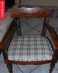 Wooden chair with blue and white checkered seat cushion on tiled floor.