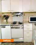 Vintage kitchen with white cabinets, gas stove, microwave, and a vase of flowers on the counter.