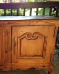 Wooden cabinet with ornate carved doors on a porch, labeled "before."