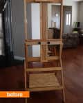 Wooden easel in a living room with hardwood floors and a floral sofa in the background.