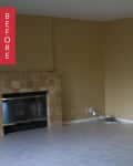 Empty living room with beige walls, tiled floor, and a stone fireplace.