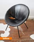 Worn black leather chair with a tear in the seat on a wooden floor.
