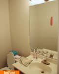 Small bathroom with beige walls, a mirror, light fixture, sink with toiletries, and a toilet with a blue lid.