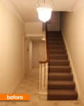 Narrow hallway with carpeted stairs, white walls, and a hanging light fixture.