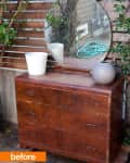 Weathered wooden dresser with round mirror, white pot, and gray vase in outdoor setting.