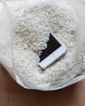 Smartphone submerged in a plastic bag filled with uncooked rice
