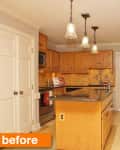 Wooden kitchen with black granite countertops, island, stainless steel appliances, and pendant lighting.