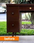 Brown wooden desk with six drawers and brass knobs, labeled "before," placed outdoors on a concrete path.