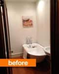 Narrow bathroom with a freestanding bathtub, wall art, and wooden floor.