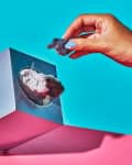 A person picks up a dryer lint from a tissue box