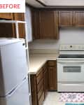 U-shaped kitchen with wooden cabinets, white appliances, and dual sink.