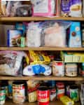 Cluttered pantry shelves with various packaged foods, canned goods, and baking supplies.