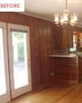 Wood-paneled kitchen with chandelier, white fridge, and open shelving.