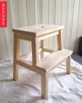 Unfinished wooden step stool on a white cloth with a "Before" label.