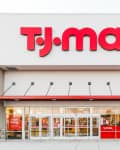 T.J.Maxx storefront with large red logo, glass entrance, and "now hiring" sign.