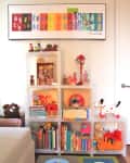 Colorful children's room with toy shelves, books, plush toys, and a Matisse-inspired artwork above.