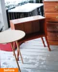 Wooden side table and dresser on a snowy porch with a small round table.