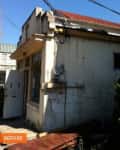 Small, weathered house with red roof, white walls, and visible utility meters, labeled "before."
