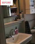 Small bathroom with sink, mirror cabinet, toiletries, towel, and window.