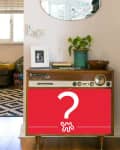 Vintage stereo console with a potted plant, framed photo, and books, beneath an oval mirror in a cozy living room.