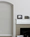 Arched wall niche beside a fireplace mantel with framed photo and decor.