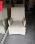Cream upholstered armchair with subtle dot pattern in a garage setting.