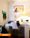 Home office with white desk, chair, table lamp, wall art, and jewelry organizer.