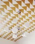 Geometric gold and white triangle ceiling with modern chrome and globe light fixture.