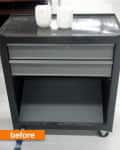 Metal rolling cart with two drawers and two white candles on top.