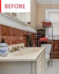 Small bathroom with brown tiles, white sink, patterned shower curtain, and metal shelf holding towels and a basket.