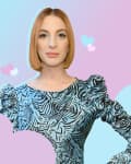 Woman in a blue patterned dress with puffed sleeves, standing against a pastel background with heart shapes.