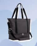 Dark gray tote bag with black handles and detachable shoulder strap on a blue abstract background.