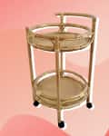 Rattan bar cart with two circular shelves and wheels on a pink wavy background.