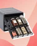 Spice rack organizer with pull-out drawers holding various spice jars.