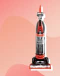 Red and black upright vacuum cleaner with a transparent dustbin on a pink abstract background.