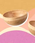 Two wooden bowls on a colorful abstract background with pink, yellow, and beige waves.