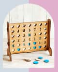 Wooden Connect Four game with heart-shaped cutouts, personalized with letters and numbers, and blue and white discs.