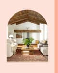 Cozy living room with wooden beams, white sofas, a wooden coffee table, and a red patterned rug. Cream bean bag and white storage box.