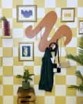 Yellow and white checkerboard wall in entry way with swirl hanging rack and hanging artwork.