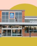 Front view of an Aldi food market with brick facade and large windows.