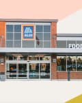 Brick exterior of an Aldi food market with large windows and entrance.
