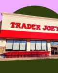 Trader Joe's storefront with red awning, shopping carts, and a person entering.