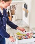 Woman smiling while she organizes a junk drawer