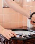 Someone using dishwasher tablets in sink